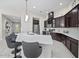 Stunning kitchen featuring a large island, dark wood cabinets, and stainless steel appliances at 118 Grande Belfly Way, Daytona Beach, FL 32124