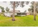 Spacious backyard with lush green grass, mature trees, and a white home at 134 Deskin Dr, South Daytona, FL 32119