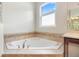 Bathroom featuring a corner soaking tub with tile surround and window at 1341 Hayton Ave, Deland, FL 32724
