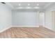 Neutral living room with wood floors, recessed lighting, tray ceiling, and an open hallway at 1341 Hayton Ave, Deland, FL 32724
