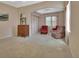 Spacious bedroom with neutral carpet, a floral mural, and a cozy seating area with red armchairs at 1491 W Silver Hammock, Deland, FL 32720