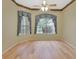 Sunlit bedroom with two large windows, gray drapes, neutral walls, ceiling fan and light hardwood flooring at 1491 W Silver Hammock, Deland, FL 32720