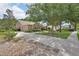 Attractive single-story home featuring mature trees, a two-car garage, and an American flag at 1491 W Silver Hammock, Deland, FL 32720