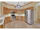 Open concept kitchen boasts stainless steel appliances, wood cabinets and tile floors at 1491 W Silver Hammock, Deland, FL 32720