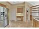 Open concept kitchen features a built-in desk area, stainless steel refrigerator and tile floors at 1491 W Silver Hammock, Deland, FL 32720