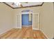 Bright office space featuring hardwood floors, ceiling fan, and double French doors leading to a blue accent wall at 1491 W Silver Hammock, Deland, FL 32720