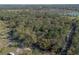 Birds-eye view of a secluded property amid lush greenery, with a residential area and lake nearby at 1712 Alanson Dr, Deland, FL 32724
