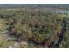 The property with red boundary lines sits among trees near other open lots, a neighboring residential area nearby at 1712 Alanson Dr, Deland, FL 32724
