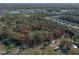Aerial view showcases a treed property's boundaries marked in red, bordering a residential area and open spaces at 1712 Alanson Dr, Deland, FL 32724