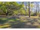 Spacious backyard with a swing set, fire pit, and mature trees at 1712 Alanson Dr, Deland, FL 32724