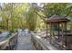 Beautiful backyard with a gazebo, two chairs, lush landscaping, and a bridge leading to the structures at 1712 Alanson Dr, Deland, FL 32724
