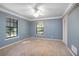 Carpeted bedroom boasts blue wallpaper, ceiling fan, double hung windows, closet and base trim at 1712 Alanson Dr, Deland, FL 32724