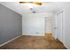 Carpeted bedroom features a ceiling fan, painted walls, and closet at 1712 Alanson Dr, Deland, FL 32724