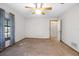 Bedroom featuring carpet, ceiling fan, one window with decorative curtains and an interior door at 1712 Alanson Dr, Deland, FL 32724