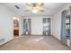 Bright bedroom featuring carpet, ceiling fan, and two windows with decorative curtains at 1712 Alanson Dr, Deland, FL 32724