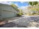 Side view of a two-car garage with a long driveway and lots of mature trees at 1712 Alanson Dr, Deland, FL 32724