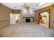 Spacious living room features wood paneling, carpet flooring, stone fireplace and open access to kitchen at 1712 Alanson Dr, Deland, FL 32724