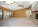 Bright living room boasts wood paneling, skylight, carpet flooring and stone fireplace at 1712 Alanson Dr, Deland, FL 32724