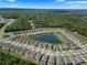 Aerial view of a planned community featuring single-Gathering homes surrounding a picturesque lake and green spaces at 1716 Red Rock Rd, New Smyrna Beach, FL 32168