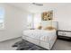 Bright primary bedroom features a plush bed with a tufted headboard, neutral color palette, and wood-look tile floors at 1716 Red Rock Rd, New Smyrna Beach, FL 32168
