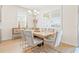 Bright dining area with table for six, decorative chandelier, and natural light streaming through the shuttered windows at 1716 Red Rock Rd, New Smyrna Beach, FL 32168