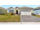 Charming single-Gathering home featuring a well-maintained lawn, an attached garage, and stone veneer accents at 1716 Red Rock Rd, New Smyrna Beach, FL 32168