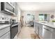 Modern kitchen features stainless steel appliances, gray cabinets, white subway tile backsplash, and wood-look tile floors at 1716 Red Rock Rd, New Smyrna Beach, FL 32168