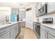 Modern kitchen features stainless steel appliances, gray cabinets, white subway tile backsplash, and wood-look tile floors at 1716 Red Rock Rd, New Smyrna Beach, FL 32168