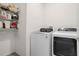 Laundry room with white washer and dryer and shelving at 1716 Red Rock Rd, New Smyrna Beach, FL 32168