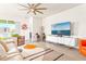 Spacious living room featuring tile floors, a modern ceiling fan, comfortable seating, and entertainment center at 1716 Red Rock Rd, New Smyrna Beach, FL 32168