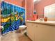 Bathroom with a colorful turtle-themed shower curtain and neutral tiling at 1751 Creekwater Blvd, Port Orange, FL 32128