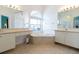 Bright bathroom with dual vanities, an arched window, and a soaking tub at 1751 Creekwater Blvd, Port Orange, FL 32128