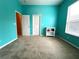 Bright bedroom with teal walls, plush carpet, and natural light from the large window at 1751 Creekwater Blvd, Port Orange, FL 32128