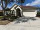 A beautiful home featuring a two-car garage, arched entryway, and meticulously landscaped yard at 1751 Creekwater Blvd, Port Orange, FL 32128