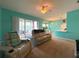 Bright and airy living room with comfortable seating, ceiling fan, and sliding glass doors to the patio at 1751 Creekwater Blvd, Port Orange, FL 32128