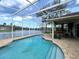 Screened-in pool with brick paver deck and view of the lake and neighboring homes at 1751 Creekwater Blvd, Port Orange, FL 32128