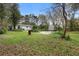 Expansive backyard with mature trees, lush greenery, and a detached storage shed, ideal for outdoor activities at 1930 S Clara Ave, Deland, FL 32720