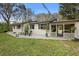 Charming white brick home featuring a cozy patio area with chairs and a fire pit at 1930 S Clara Ave, Deland, FL 32720