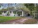 Charming white brick home with a well-maintained lawn, covered porch, and convenient carport at 1930 S Clara Ave, Deland, FL 32720