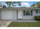 Close up of the home's front door and attached one car garage at 1986 Big Oak Dr, South Daytona, FL 32119