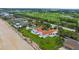 Aerial view of an oceanfront home close to a golf course with a pool and manicured lawn at 201 Ocean Shore Blvd, Ormond Beach, FL 32176