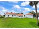 Manicured backyard with lush grass and Spanish style home overlooking the ocean at 201 Ocean Shore Blvd, Ormond Beach, FL 32176