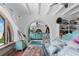 Bright bedroom with exposed beams boasts an ocean view and a unique archway leading to a turquoise vanity area at 201 Ocean Shore Blvd, Ormond Beach, FL 32176