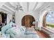 Airy bedroom with white walls features exposed beams, a turquoise bed, and a view of the ocean at 201 Ocean Shore Blvd, Ormond Beach, FL 32176