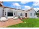 Charming white home with a red tile roof, brick patio, and lush lawn offering a relaxed outdoor space at 201 Ocean Shore Blvd, Ormond Beach, FL 32176