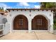 A Spanish style home's garage features custom wood doors and decorative accents at 201 Ocean Shore Blvd, Ormond Beach, FL 32176