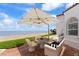 Stylish patio setup with modern furniture, an umbrella and an ocean view by the beach house at 201 Ocean Shore Blvd, Ormond Beach, FL 32176