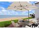 Outdoor patio with beach views, an umbrella-covered table, and stylish seating. Perfect for enjoying the ocean breeze at 201 Ocean Shore Blvd, Ormond Beach, FL 32176