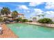 Large in-ground pool with brick trim surrounded by lush landscaping and white buildings at 201 Ocean Shore Blvd, Ormond Beach, FL 32176