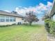 Well maintained back yard with lush green grass, mature tree, and white fence at 202 Oakleigh Dr # 90, Deland, FL 32724